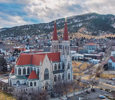 a church with red roofs and a mountain in the background