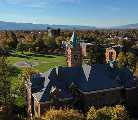 a building with a clock tower in the middle of a park